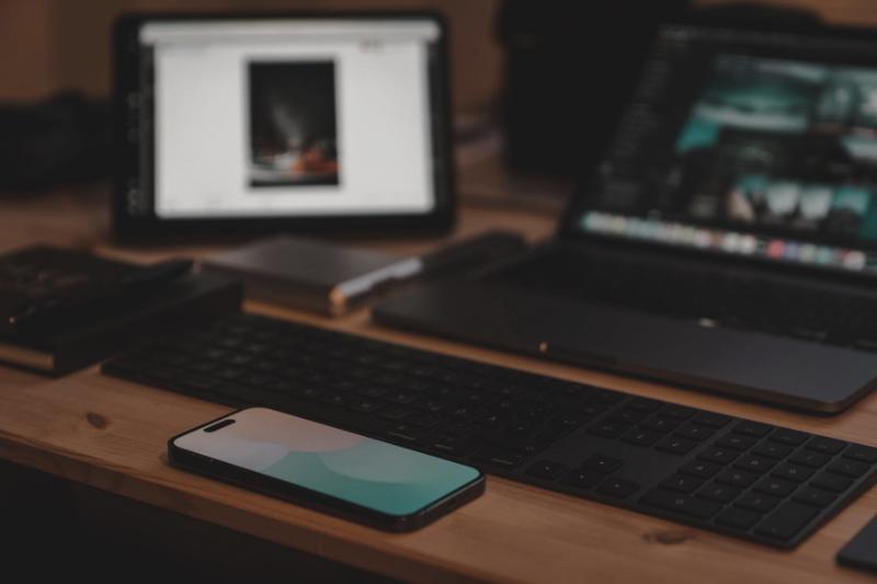 Tablet, laptop y teléfono sobre un escritorio de madera